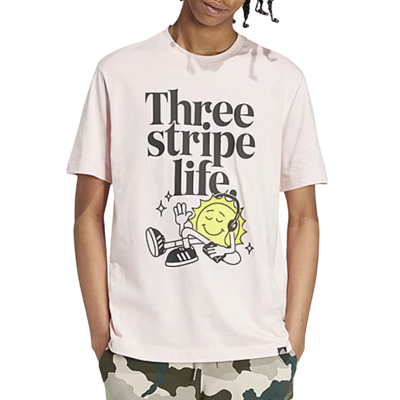 A pink T-shirt featuring the phrase \“Three stripe life\“ and a graphic of a relaxed yellow character with headphones, paired with camouflage pants.