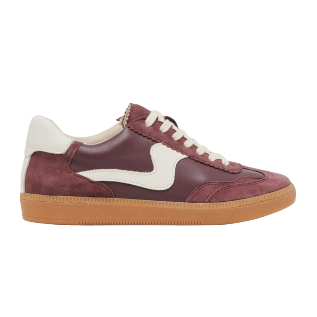 Dolce Vita Notice Sneakers feature a burgundy leather upper with white suede accents, a white wavy side stripe, cream laces, and a tan rubber sole, offering a retro-inspired look.