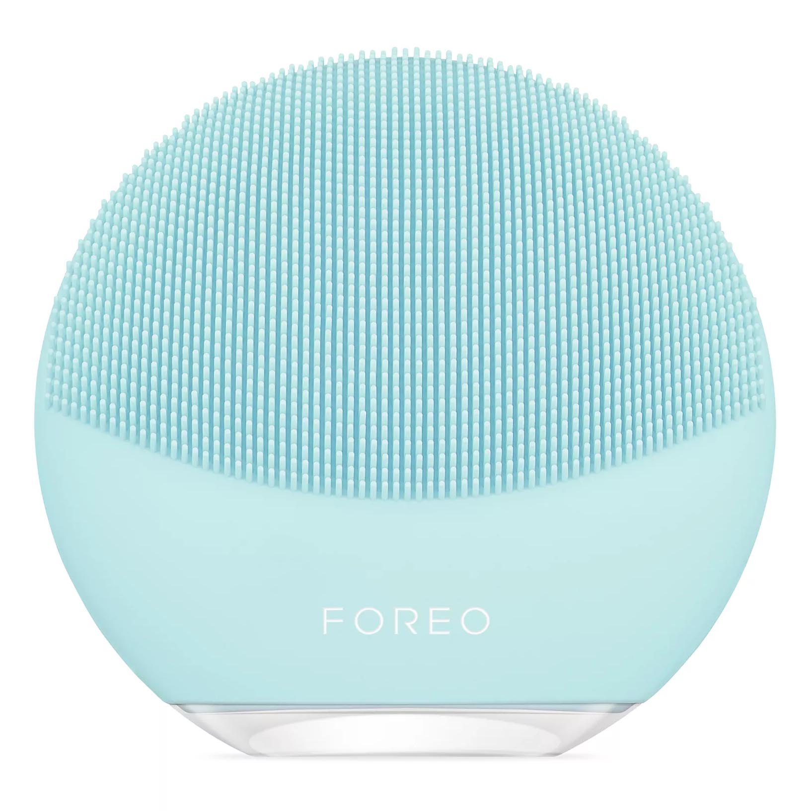 A light blue facial cleansing brush with silicone bristles, labeled \“Foreo,\“ designed for gentle skin care.