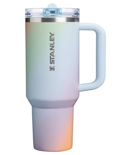 A Stanley insulated tumbler with a handle and a lid, featuring a gradient color design.