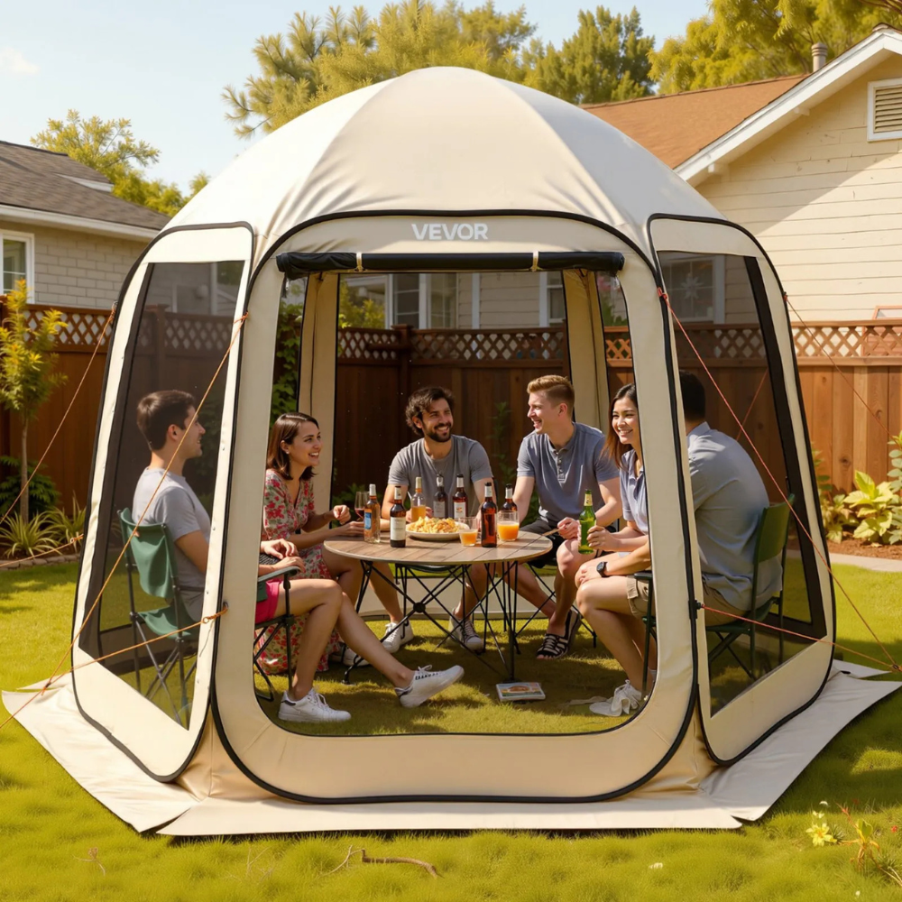A group of people is seated inside a VEVOR pop-up gazebo tent enjoying drinks and snacks, set up in a backyard.