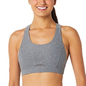 A woman wearing a gray sports bra with a racerback design and minimal stitching, suitable for athletic activities.