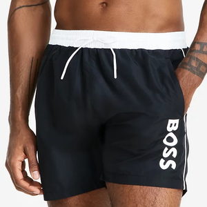 Black swim trunks with a white elastic waistband and drawstring. The word \“BOSS\“ is prominently printed in white on the side.
