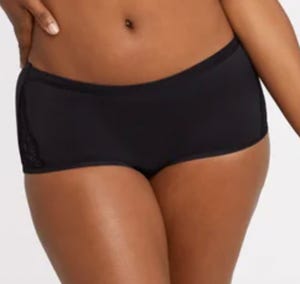 A person wearing black swim shorts.