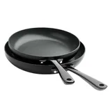 Two black non-stick frying pans with matching handles, stacked together.