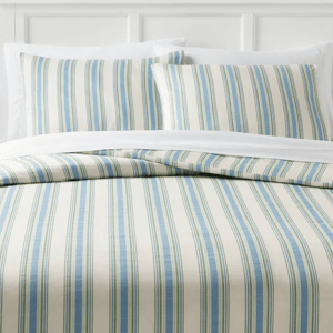 Striped bedding set featuring a pattern of blue and green vertical lines on a cream background, including a duvet and two pillowcases.