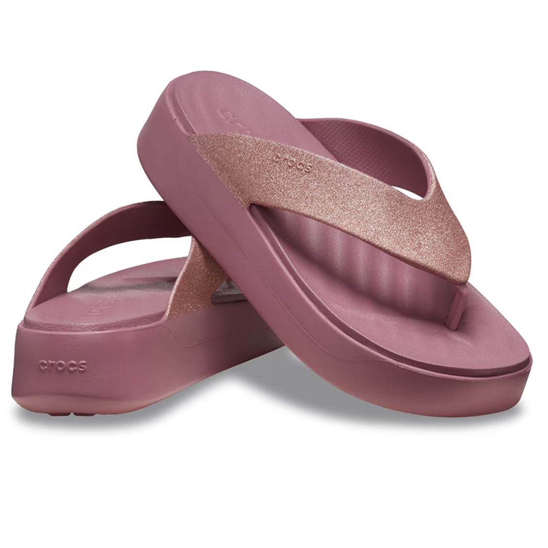 A pair of mauve-colored, platform flip-flops with a glittery strap.