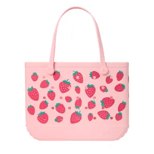 Pink tote bag with strawberry pattern and \“bogg\“ embossed on the lower front.