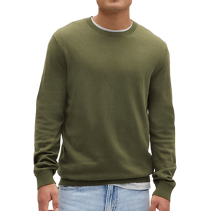 A person is wearing a plain olive green sweater with long sleeves paired with light blue jeans.