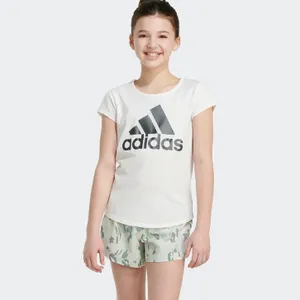 A young person is wearing a white t-shirt with the Adidas logo and camo print shorts.