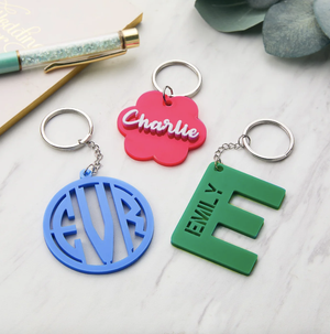 Three custom keychains with various colors and personalized with names or initials.