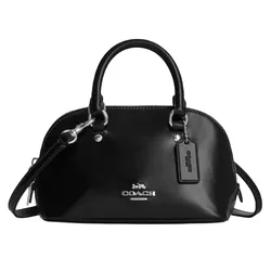 A black Coach handbag with a structured dome shape, two top handles, a detachable shoulder strap, and silver hardware, including a Coach tag.