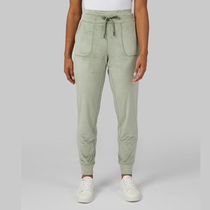 Light green sweatpants with drawstring waist and white sneakers on a person.