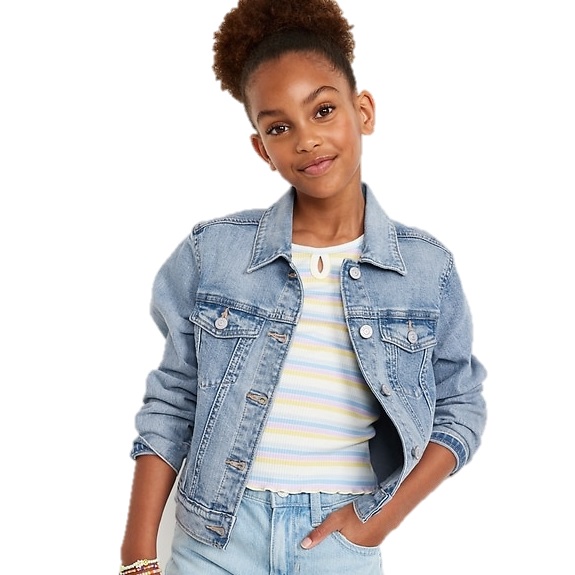 A young girl wearing a light blue denim jacket over a striped pastel top paired with light blue jeans.