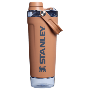 20oz Stanley New Shaker Bottle in a tan color with a dark blue logo. Features include a secure flip-top lid, a carry handle, and a clear base. Ideal for mixing drinks on the go.