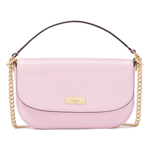 A pastel pink shoulder bag with a glossy finish, gold chain accents, and a flap closure featuring a small gold brand plaque.
