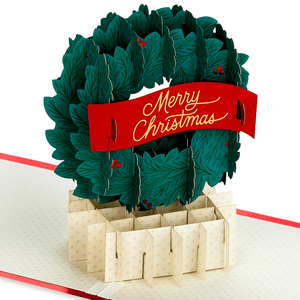 Pop-up Christmas card featuring a 3D wreath with a \“Merry Christmas\“ banner.