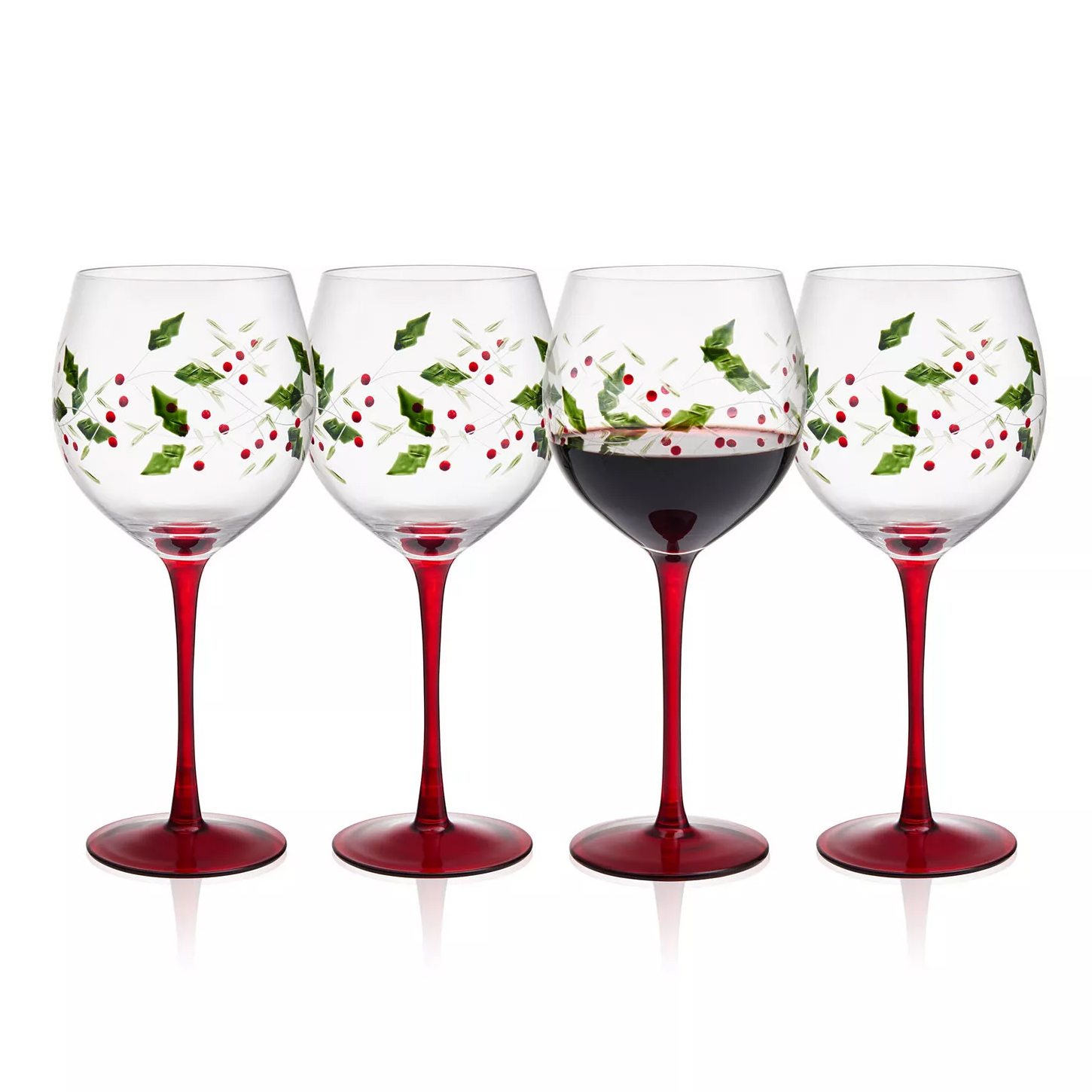 Set of four wine glasses with red stems, adorned with holly and berry designs. One glass is filled with red wine.
