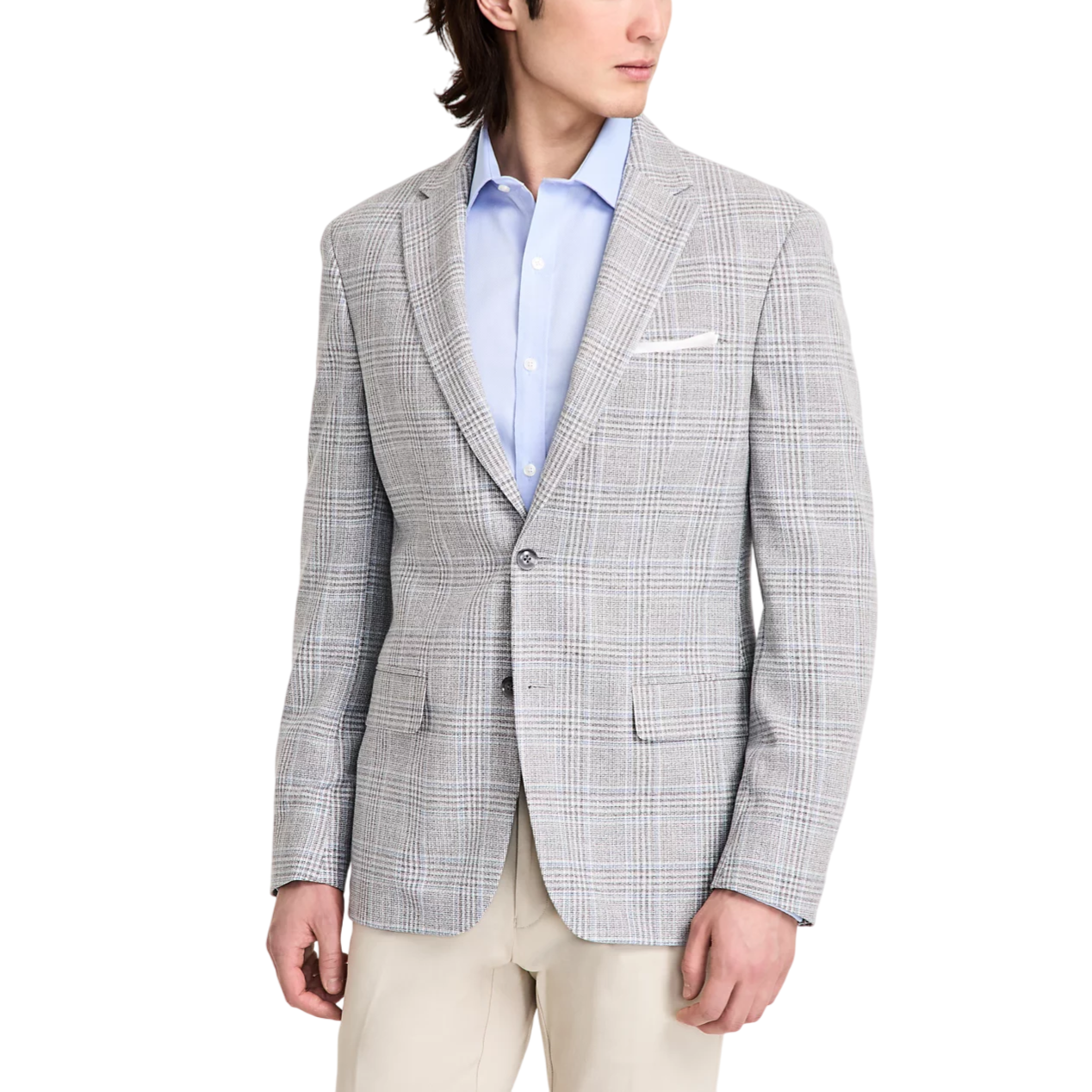 A man is wearing a light grey plaid blazer over a light blue dress shirt, paired with beige trousers.