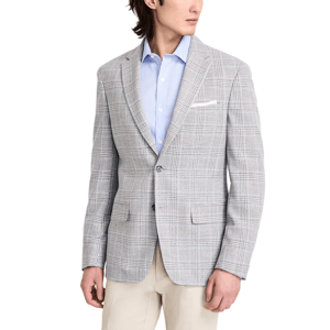 A man is wearing a light grey plaid blazer over a light blue dress shirt, paired with beige trousers.