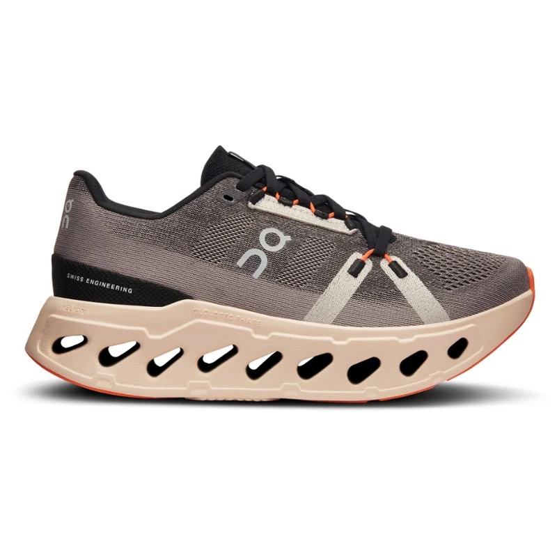 The On Cloudeclipse Road Shoes feature a breathable mesh upper, distinctive cutout sole for cushioning and flexibility, with a black, beige, and orange color scheme, and Swiss Engineering branding.
