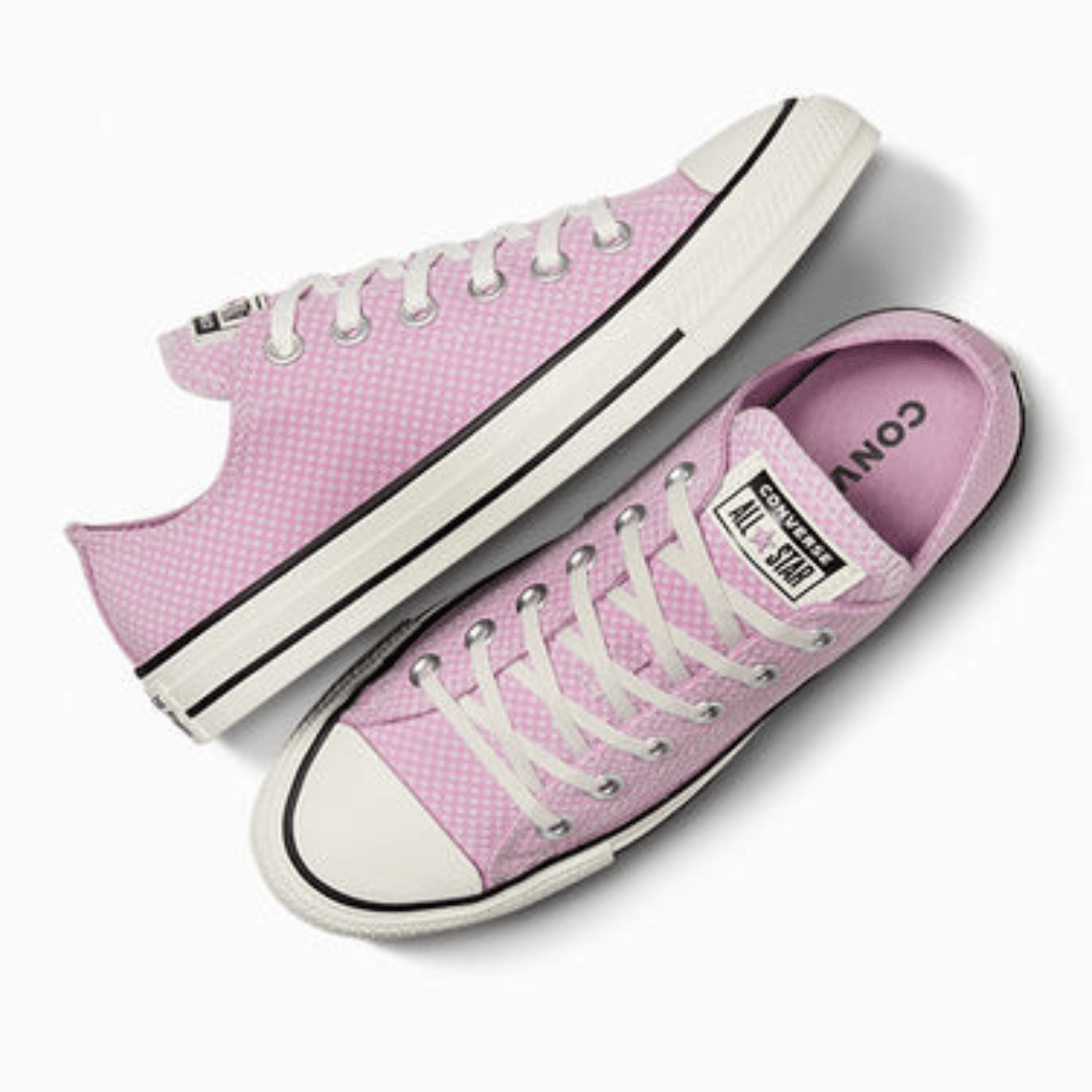 A pair of pink Converse sneakers with white laces and rubber soles.