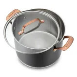 Stainless steel stockpot with a glass lid featuring copper-colored handles, marked with interior measurement indicators.