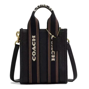 Coach black leather tote bag with wide fabric handles featuring the brand's name, detachable shoulder strap, and gold-tone hardware.