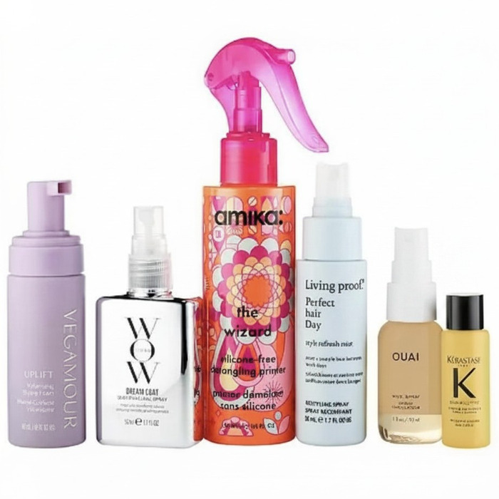 Collection of hair products includes Vegamour Uplift foam, Color Wow Dream Coat spray, Amika The Wizard detangling primer, Living Proof Perfect Hair Day mist, Ouai Wave Spray, and Kérastase Elixir Ultime.