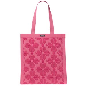 A pink tote bag featuring a textured pattern of floral designs with matching pink straps.