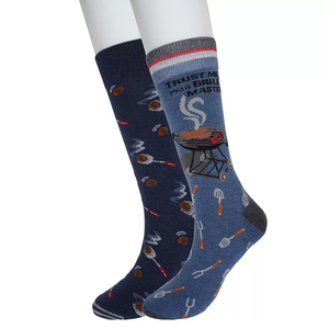 A pair of blue crew socks featuring barbecue-themed graphics; one sock has text saying \“Trust me, I'm a grill master\“ with a grill image, and the other displays various grilling tools and utensils.