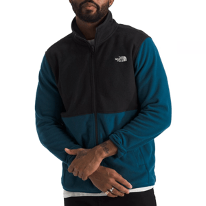 The North Face Glacier Fleece features a two-tone design with a black upper section and teal blue lower section. It has a full zip front, stand-up collar, and the logo is visible on the chest.