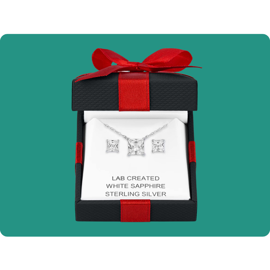 A jewelry set featuring lab-created white sapphire earrings and a necklace in sterling silver, presented in a black gift box with a red ribbon.
