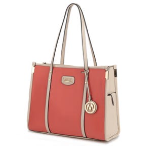 A stylish tote bag with coral and beige panels, featuring long handles and a circular charm.