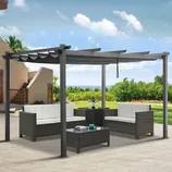 Outdoor patio set with a pergola, featuring two cushioned sofas, a matching armchair, a central coffee table with a glass top, and a side table, all in a woven rattan design.