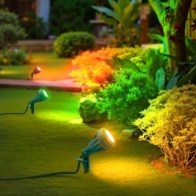 Garden landscape lights with extra lenses illuminate bushes in green, yellow, and orange hues, creating a festive ambiance.