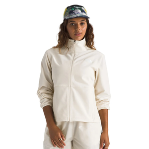 A person wears a light-colored jacket with a full zipper and elastic cuffs, paired with matching pants. They also have on a colorful cap with a logo on the front.