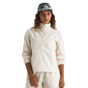 A person wears a light-colored jacket with a full zipper and elastic cuffs, paired with matching pants. They also have on a colorful cap with a logo on the front.