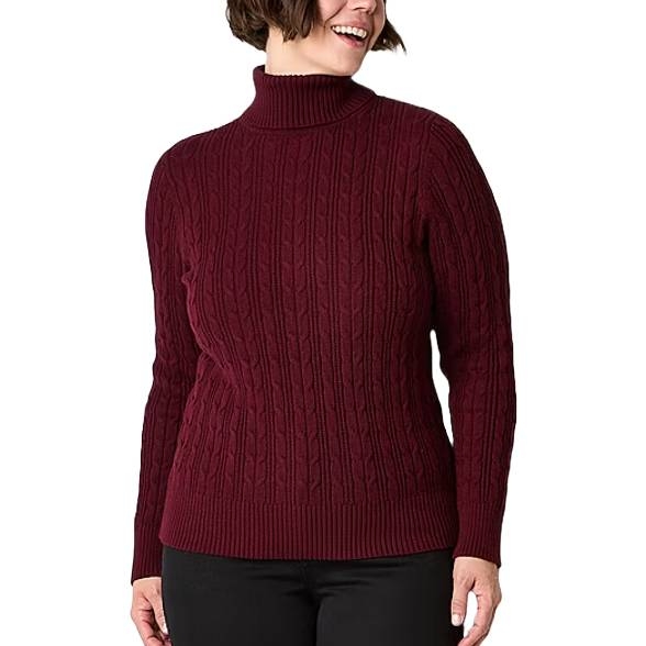A woman is wearing a maroon cable-knit turtleneck sweater paired with black pants. The sweater features a ribbed hem and cuffs.