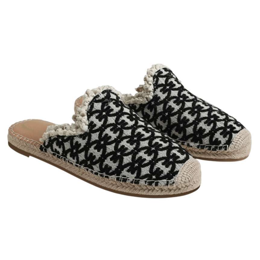 Black and white floral-patterned mule slippers with woven rope trim and frayed edges, featuring a slip-on design and textile upper.