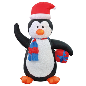 Inflatable penguin wearing a Santa hat and scarf, holding a gift. The penguin features bright orange feet and a beak, with black and white body.