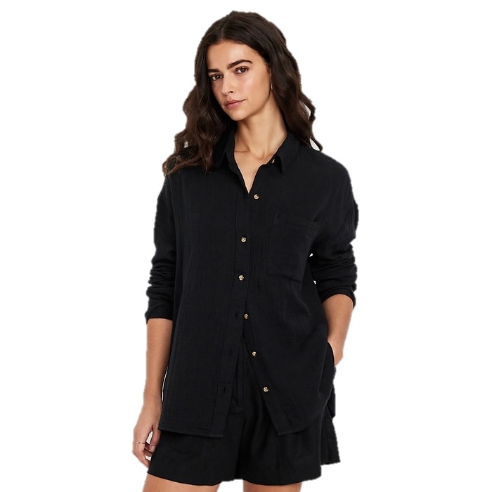 A woman is wearing a long-sleeve black button-up shirt with a collar and a chest pocket, paired with black shorts.