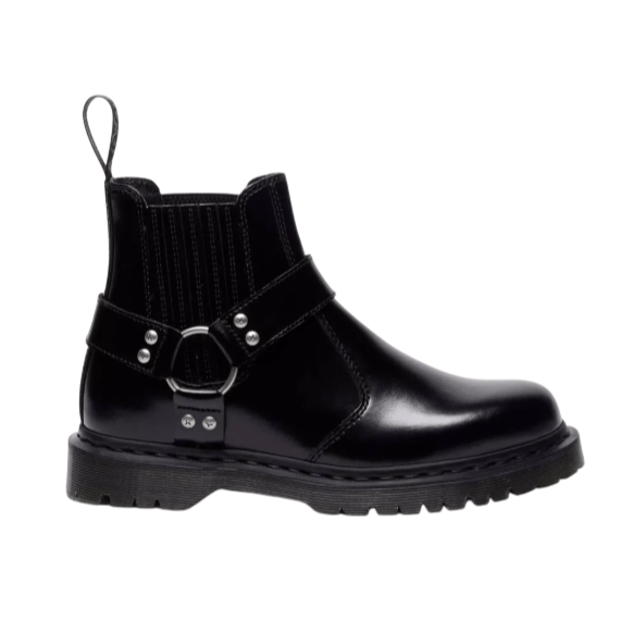 A black leather ankle boot with a chunky sole and harness strap detailing, featuring elastic side panels and a pull tab for easy wear.