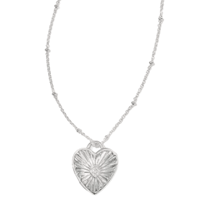 A necklace with a heart-shaped pendant featuring a sunburst design and a small central gem detail, attached to a delicately beaded chain.