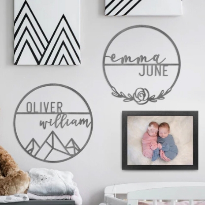 Wall art including personalized name signs and one framed photograph of two babies.