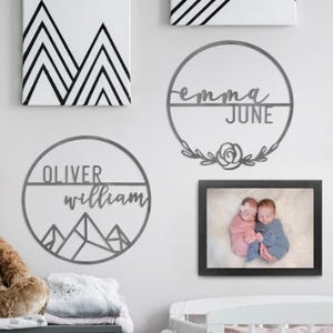 Wall art including personalized name signs and one framed photograph of two babies.