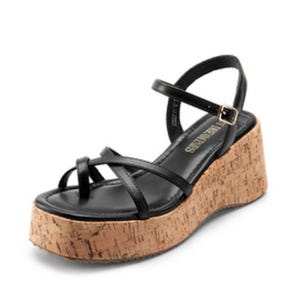 A black sandal with thin straps and an adjustable buckle, featuring a cork wedge heel.