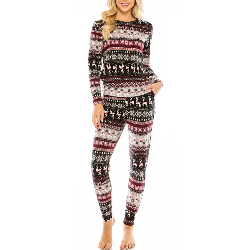 A person is wearing a cozy set of festive long-sleeve pajamas with a reindeer and snowflake pattern in black, white, red, and gray tones.