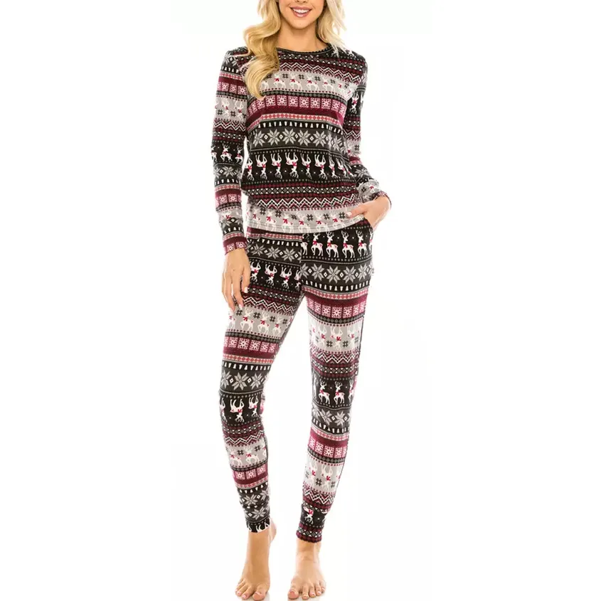 A person is wearing a cozy set of festive long-sleeve pajamas with a reindeer and snowflake pattern in black, white, red, and gray tones.