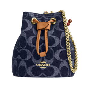 Coach Outlet Drawstring Wristlet in denim features a zip-top closure, signature logo print, leather drawstring detail, and a gold-tone chain strap with red accents.